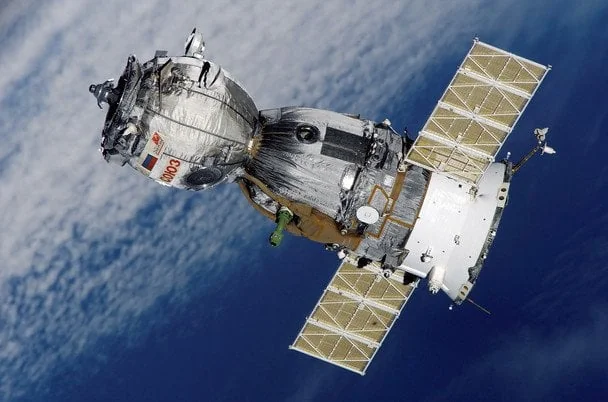 Російський космічний апарат із сонячними панелями на орбіті Землі