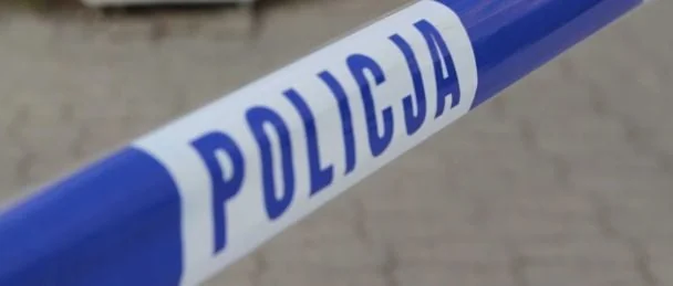 Синьо-біла стрічка польської поліції з написом POLICJA на бруківці